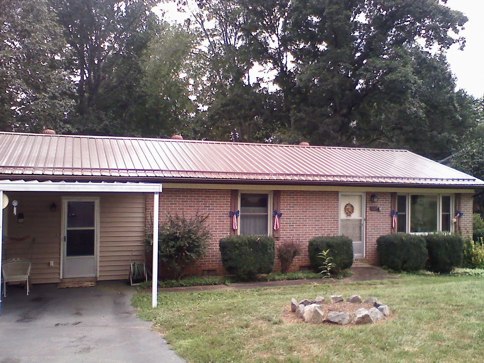 Bronze metal roof and carport on a brick ranch home — Roof Repair work by our crew in Rio